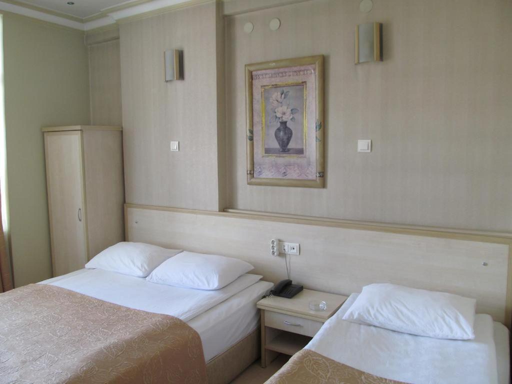 CorumにあるKOLAĞASI HOTELのベッド2台が備わる客室で、壁に絵が描かれています。