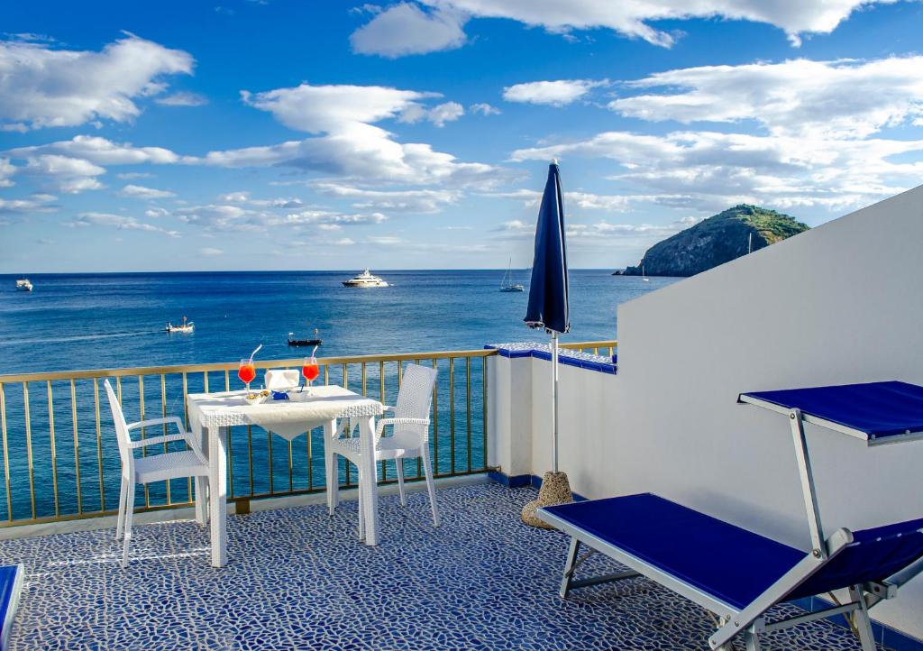 a balcony with a table and chairs and the ocean at Hotel Regina del Mare in Ischia