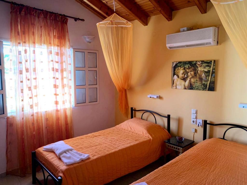 1 dormitorio con 2 camas y ventana en Palma Sidari Corfu en Sidárion