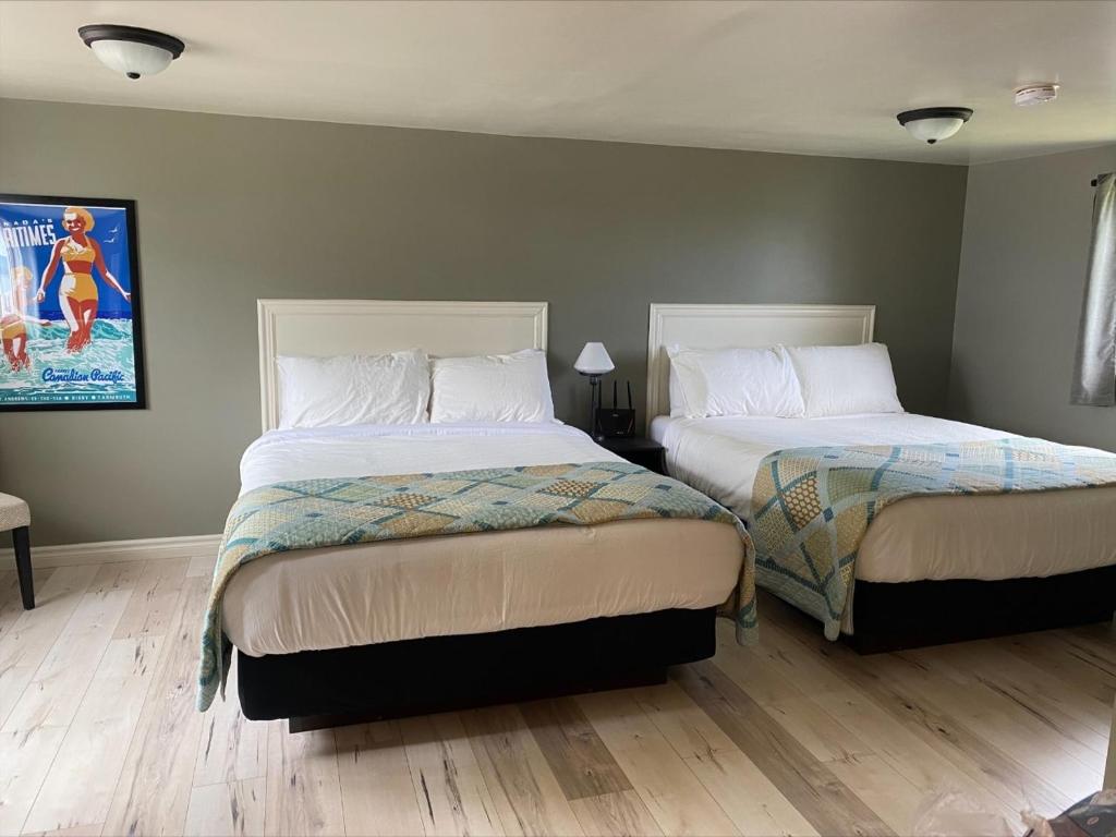 sypialnia z 2 łóżkami i obrazem na ścianie w obiekcie Seawinds Motel & Cottages w mieście Digby