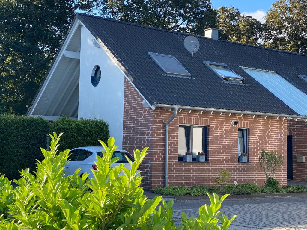 ein rotes Backsteinhaus mit Sonnenkollektoren auf dem Dach in der Unterkunft Ferienhaus Xantenamera in Xanten-Wardt am See in Xanten