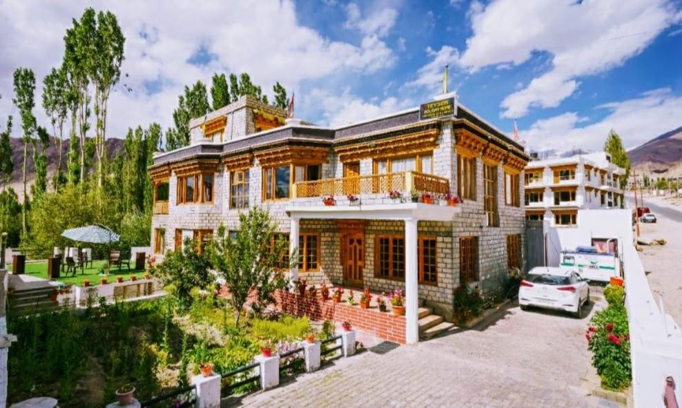 a large house with a car parked in front of it at Teyser Holiday Home in Leh