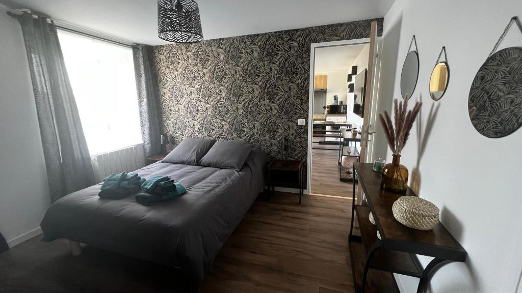 Schlafzimmer mit einem Bett, einem Tisch und einem Fenster in der Unterkunft Logement avec terrasse,4 pers, parking in Concarneau