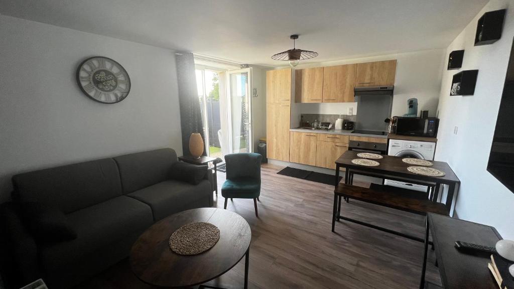 ein Wohnzimmer mit einem Sofa und einem Tisch in der Unterkunft Logement avec terrasse,4 pers, parking in Concarneau