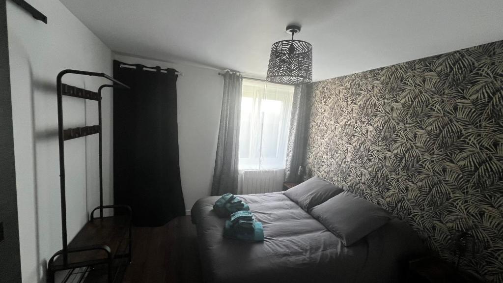 ein Schlafzimmer mit einem Bett vor einer Wand in der Unterkunft Logement avec terrasse,4 pers, parking in Concarneau