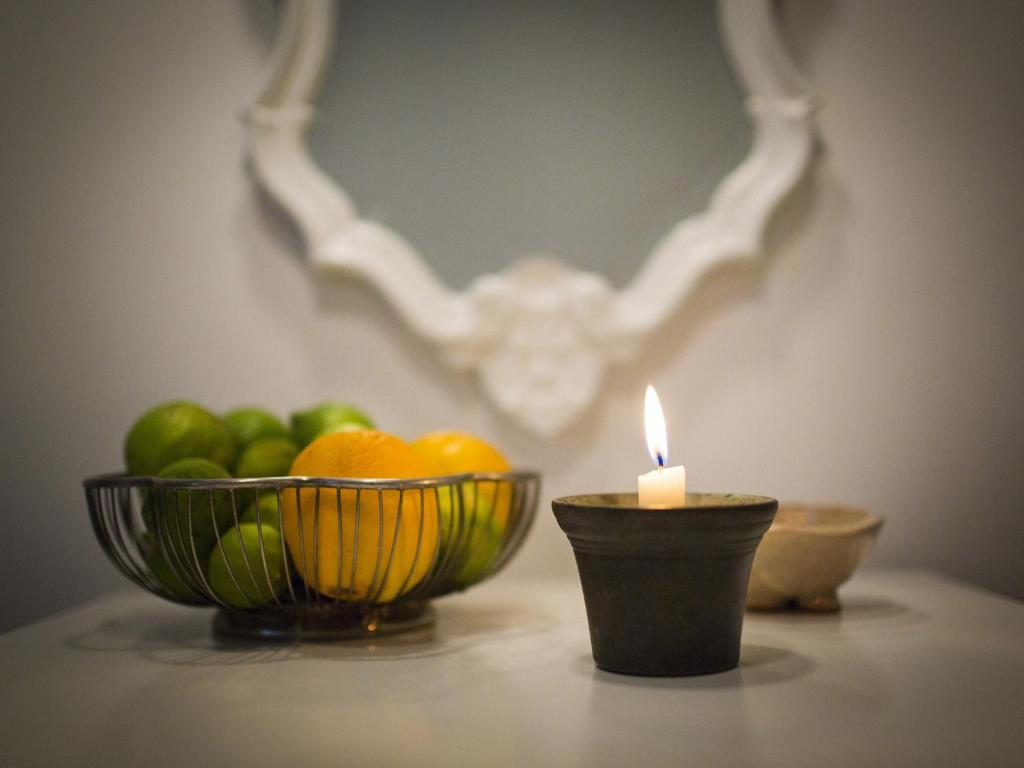 uma vela e uma taça de fruta numa mesa em Casa Teresa em Noto