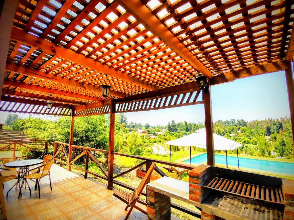 a large wooden pergola with a table and chairs on a patio at Cabañas Antukuyen ex Mawunko in Quillón