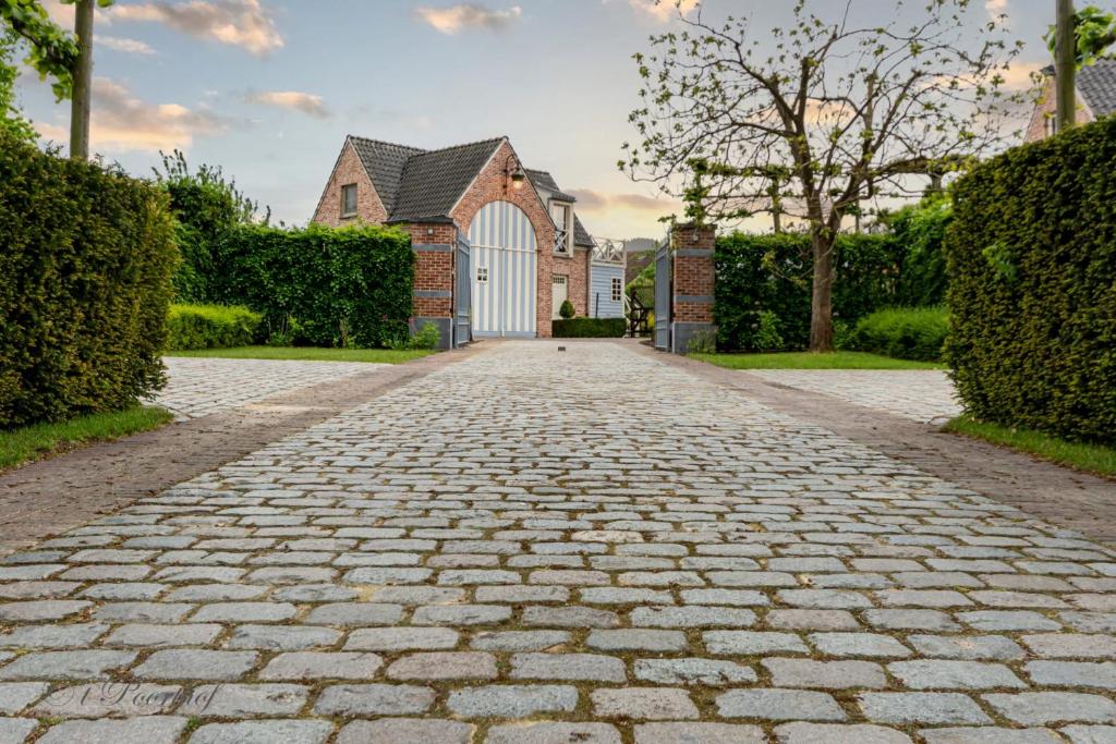a cobblestone driveway in front of a house at 't Poorthof in Borgloon