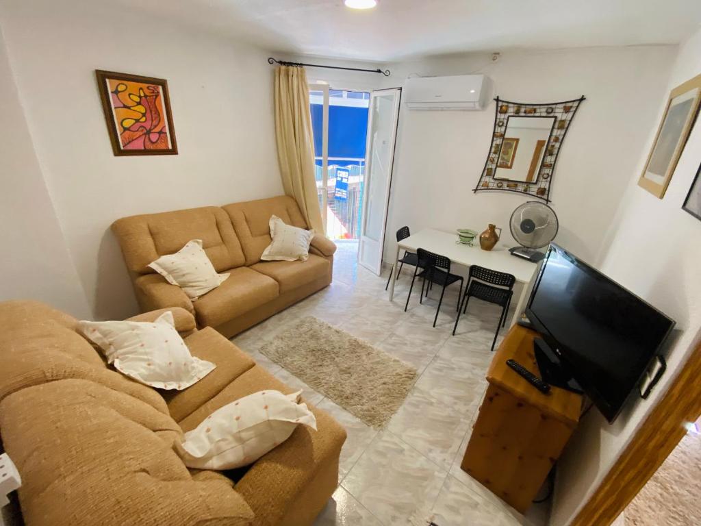 a living room with a couch and a tv at Alex Apartments in Benidorm
