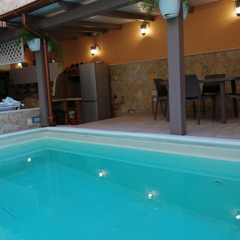 uma piscina em uma casa com mesa e cadeiras em Ivana home em Trapani
