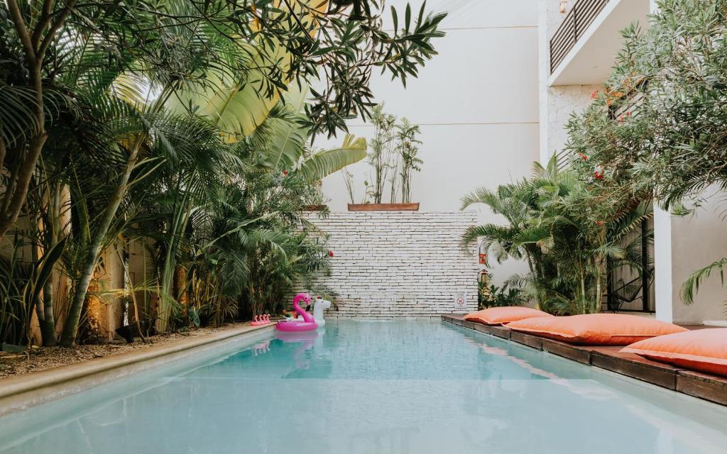 ein Schwimmbecken mit einem rosa Spielzeug in der Mitte in der Unterkunft The Strabon Tulum in Tulum