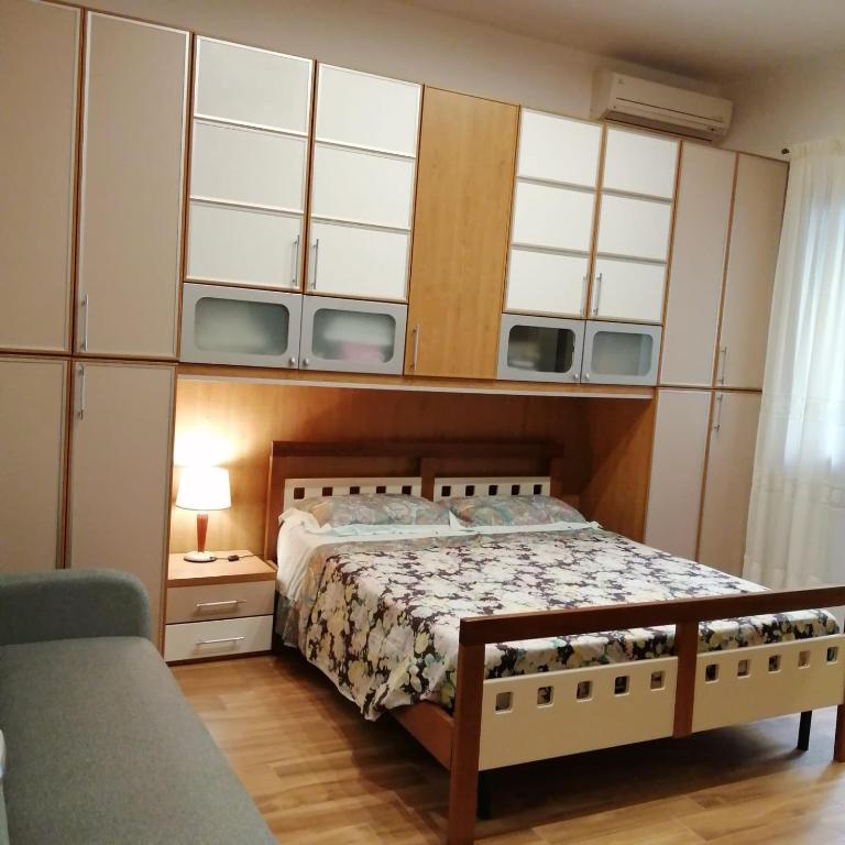 um quarto com uma cama, armários e um sofá em Ivana home em Trapani