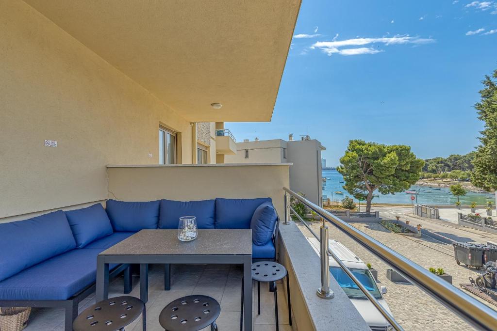 d'un canapé bleu et d'une table sur un balcon. dans l'établissement Apartment Stoja, à Pula
