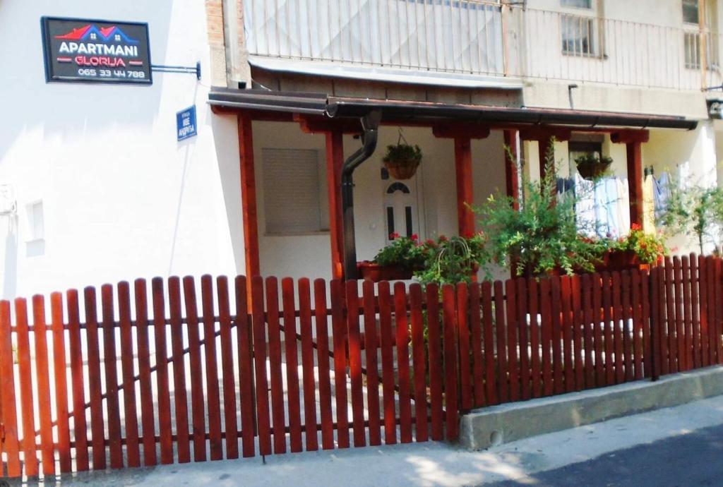 een rood hek voor een huis bij Apartmani Glorija in Arandjelovac