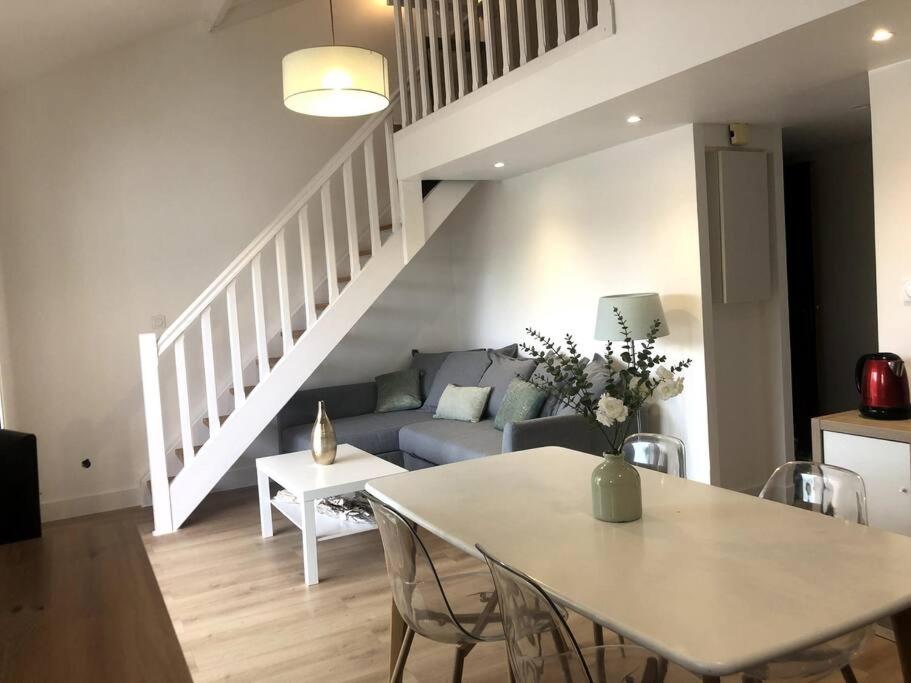 un salon avec un canapé et une table dans l'établissement Le Petit Cote Ouest - appt dans les Pins près de la plage, à Les Sables-dʼOlonne