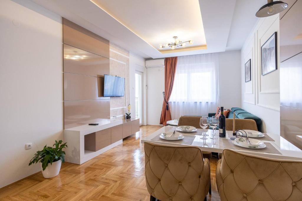 a dining room and living room with a table and chairs at Apartman Vanilla Sky in Trebinje