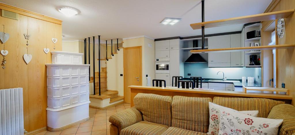 a living room with a couch and a kitchen at Bait da Marieta in Livigno