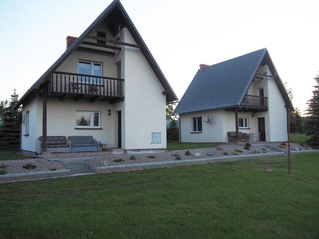 a white house with a black roof at Agroturystyka Iwona Jażdżewska in Osława Dąbrowa