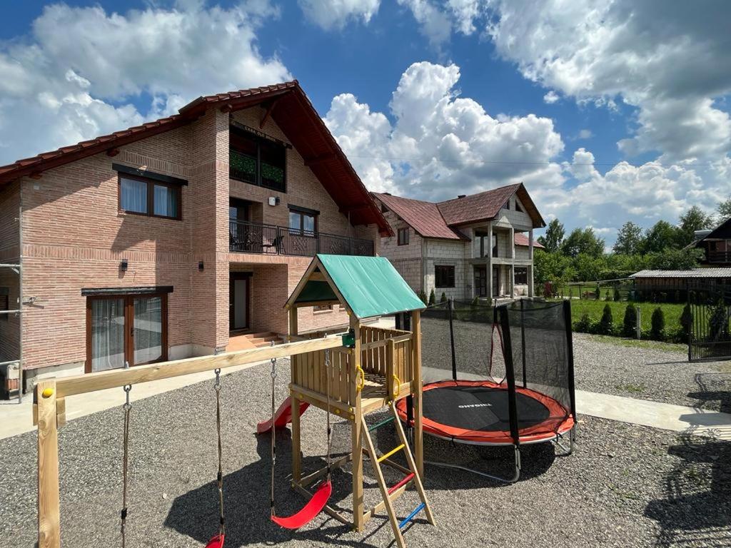a playground with a play equipment in front of a house at Casa OLD BRICK in Ocna Şugatag