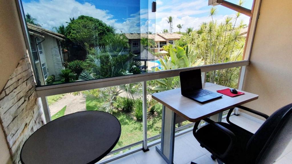 een kamer met een bureau, een laptop en een raam bij Férias na Bahia e a 200m da praia in Porto Seguro