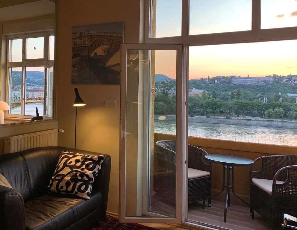 a living room with a couch and a view of a river at Riverside Gem in the city center in Budapest