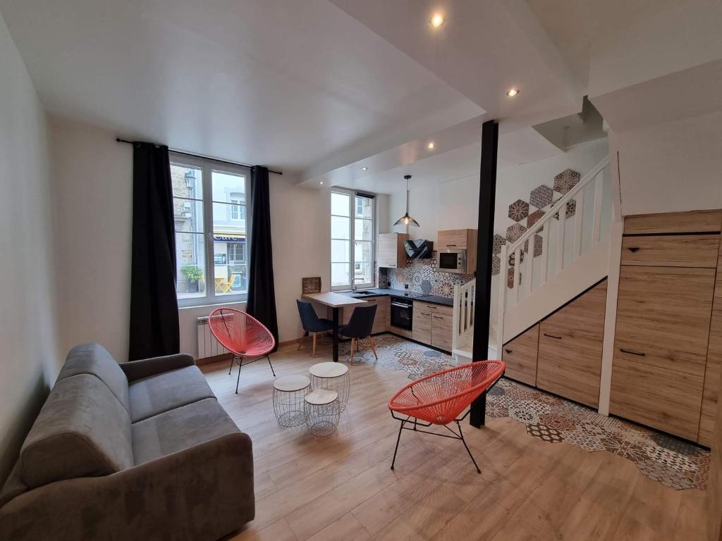 uma sala de estar com um sofá, cadeiras e uma mesa em Appartement bord de mer em Dinard