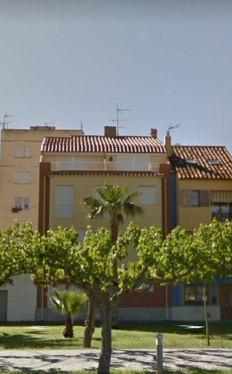 a building with a palm tree in front of a building at Dúplex playa Torrenostra in Torreblanca
