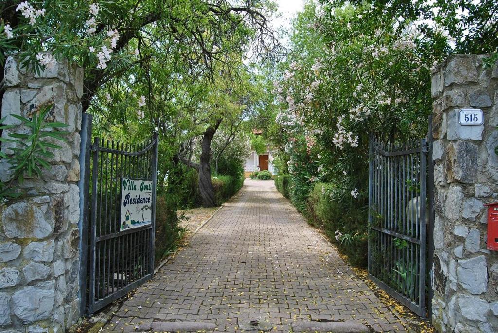 um caminho de paralelepípedos com um portão e uma parede de pedra em Villa Conti Residence em Lacona