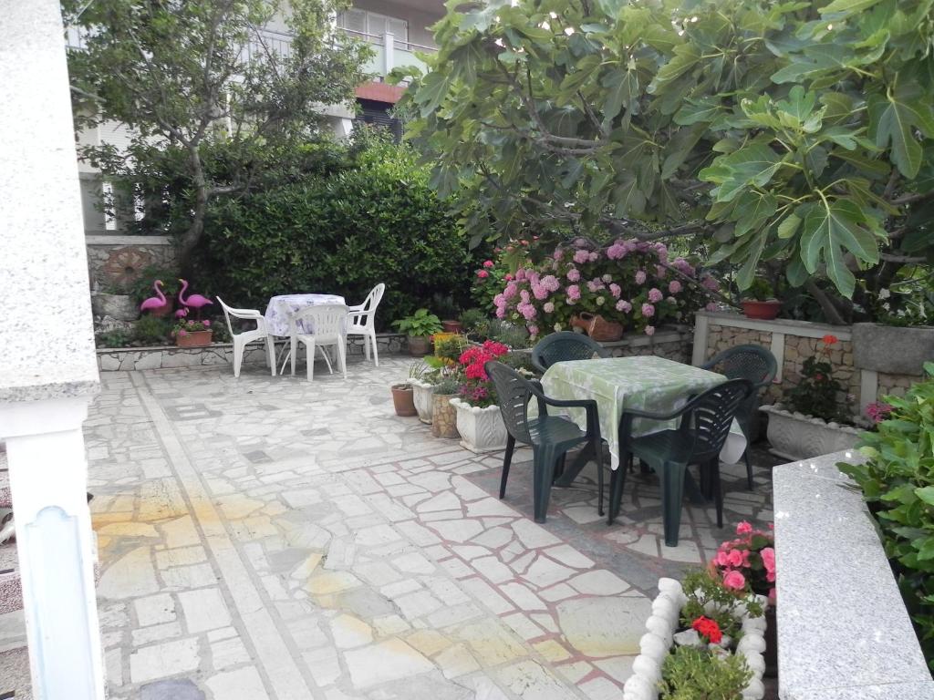 a patio with a table and chairs and flowers at Kristina in Vrbnik