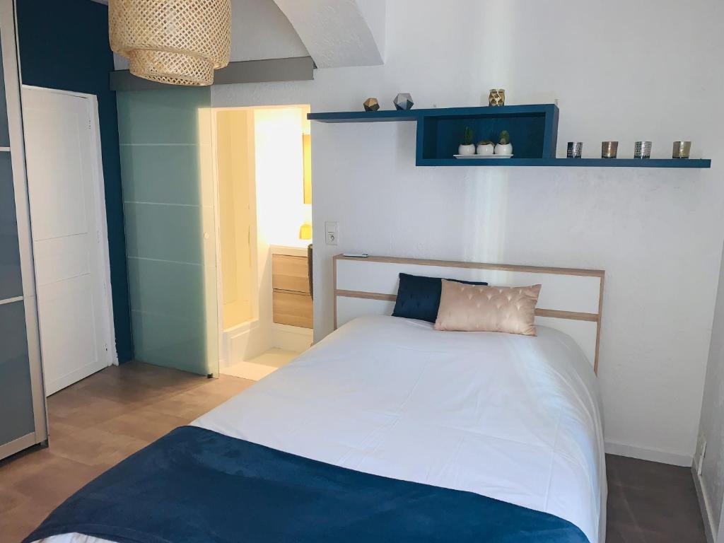 een slaapkamer met een bed in blauw en wit bij Appartement douillet Lorgues in Lorgues