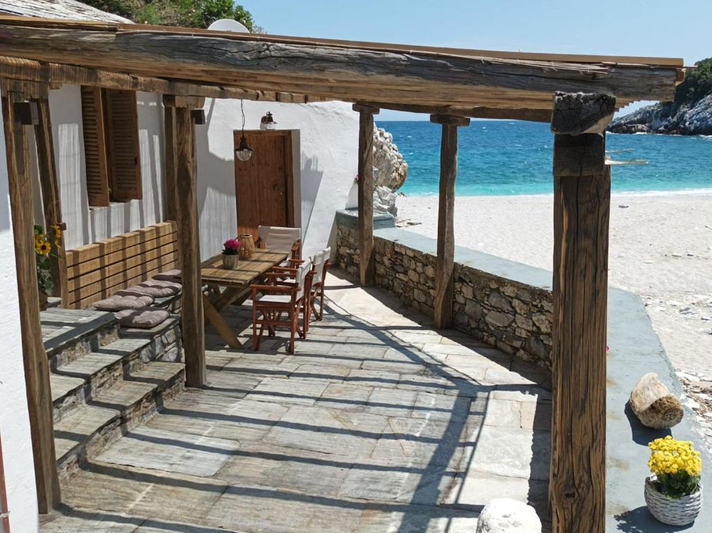 a house on the beach with a table and chairs at Κυμοθόη in Milopotamos