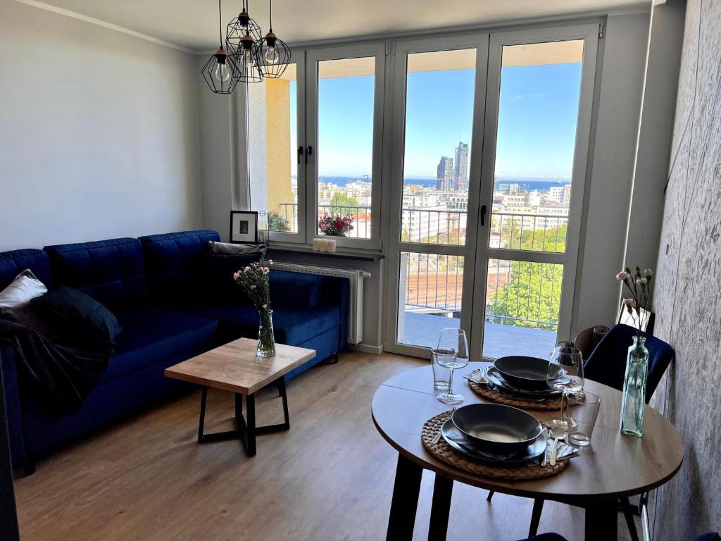 a living room with a blue couch and a table at Apartament M.55 in Gdynia