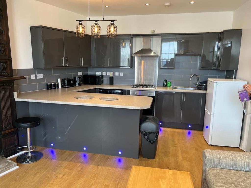 uma cozinha com armários pretos e um frigorífico branco em Entire Two Bedrooms Flat with Nice View H2 em Great Yarmouth
