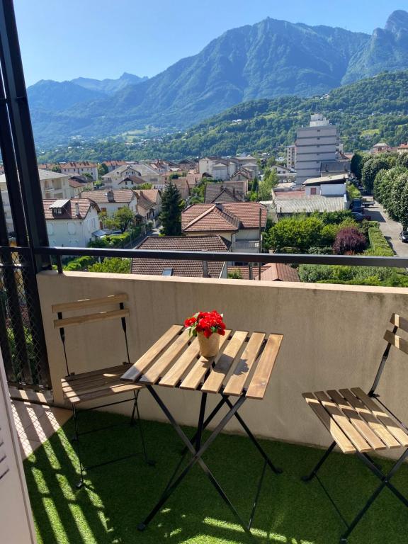 a table and chairs on a balcony with a view of a city at Magic&#39; Chambord in Albertville