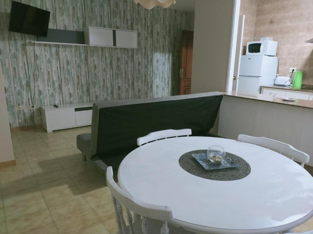 einen weißen Tisch und Stühle in einem Zimmer mit Küche in der Unterkunft CASA PORTELA APARTAMENTOS in Revolta