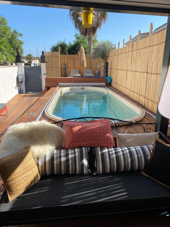 a swimming pool on a deck with a couch and a swimming pool at Little Bohême, luxe, piscine, SPA, tout à pied, Port Grimaud in Grimaud