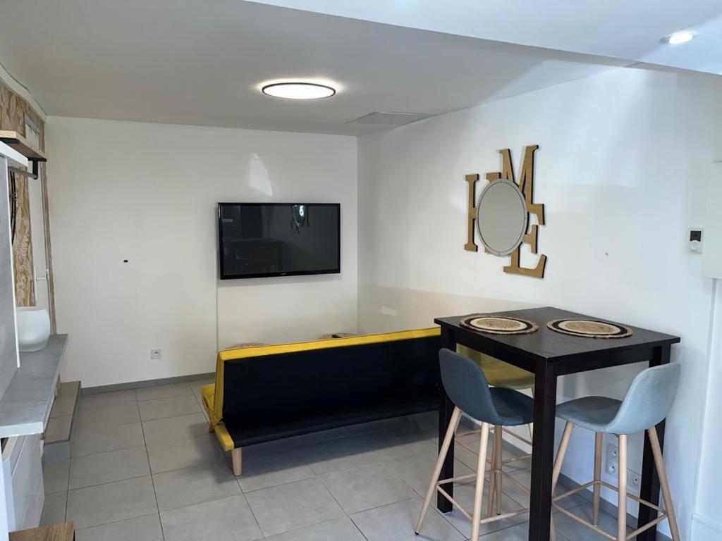 シャルトルにあるPetite maison centre villeのテーブル、鏡、テレビが備わる客室です。