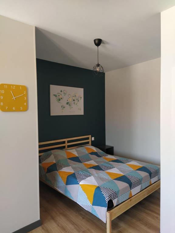 um quarto com uma cama com um edredão colorido em Forges 4 em Saujon