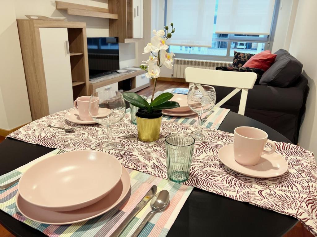 una mesa de comedor con platos y platos. en Apartamento Europa Prados - Atenea en Oviedo