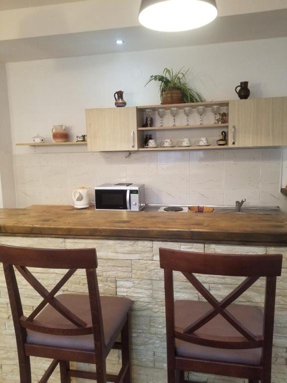 a kitchen with a counter with two chairs and a microwave at Apartments Beka in Žabljak