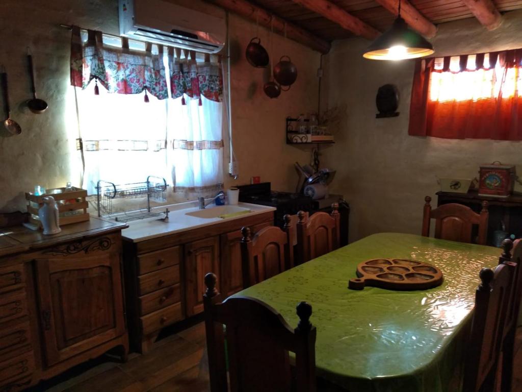 uma cozinha com uma mesa verde e um lavatório em Aires de Naturaleza em Rivadavia