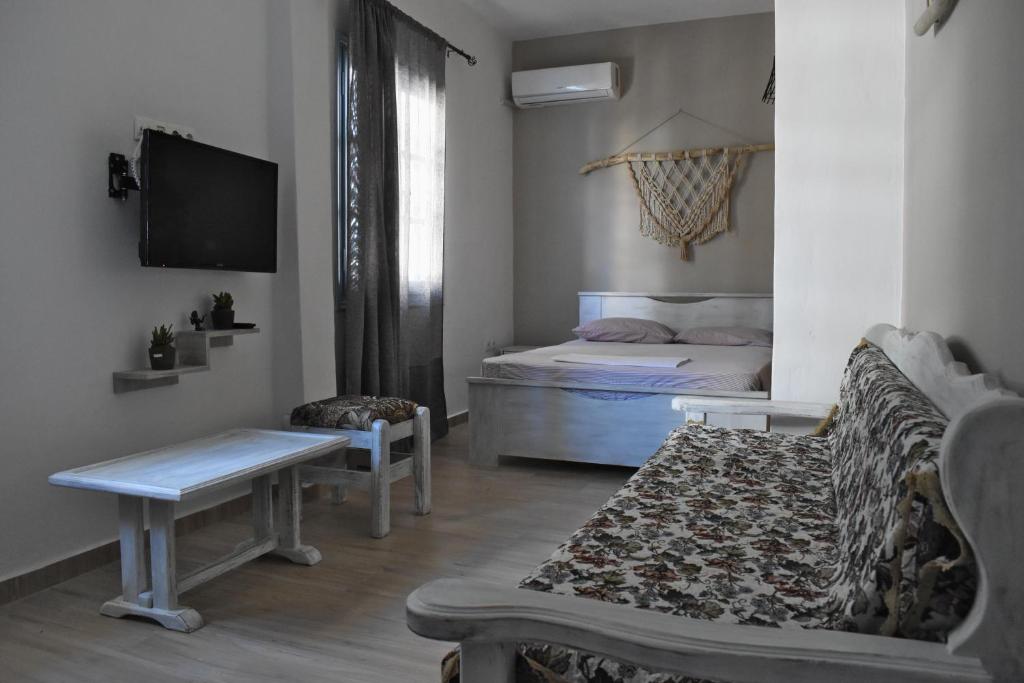 una pequeña sala de estar con sofá y cama en Voula's House en Skíathos