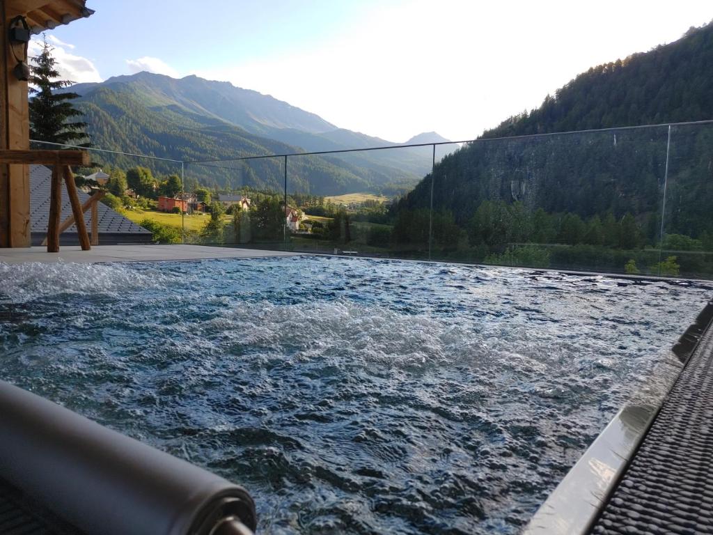 einem Wasserkörper mit einer Brücke im Hintergrund in der Unterkunft Hotel Crusch Alba Sta Maria in Sta Maria Val Müstair