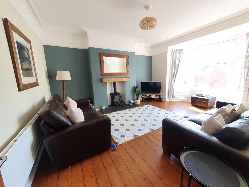 a living room with two couches and a television at Coastal escape in the heart of Saltburn in Saltburn-by-the-Sea