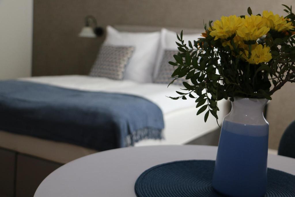 niebieska waza z żółtymi kwiatami siedzącymi na stole w obiekcie Apartament Żeromskiego 17 - Insel Apartamenty w Świnoujściu