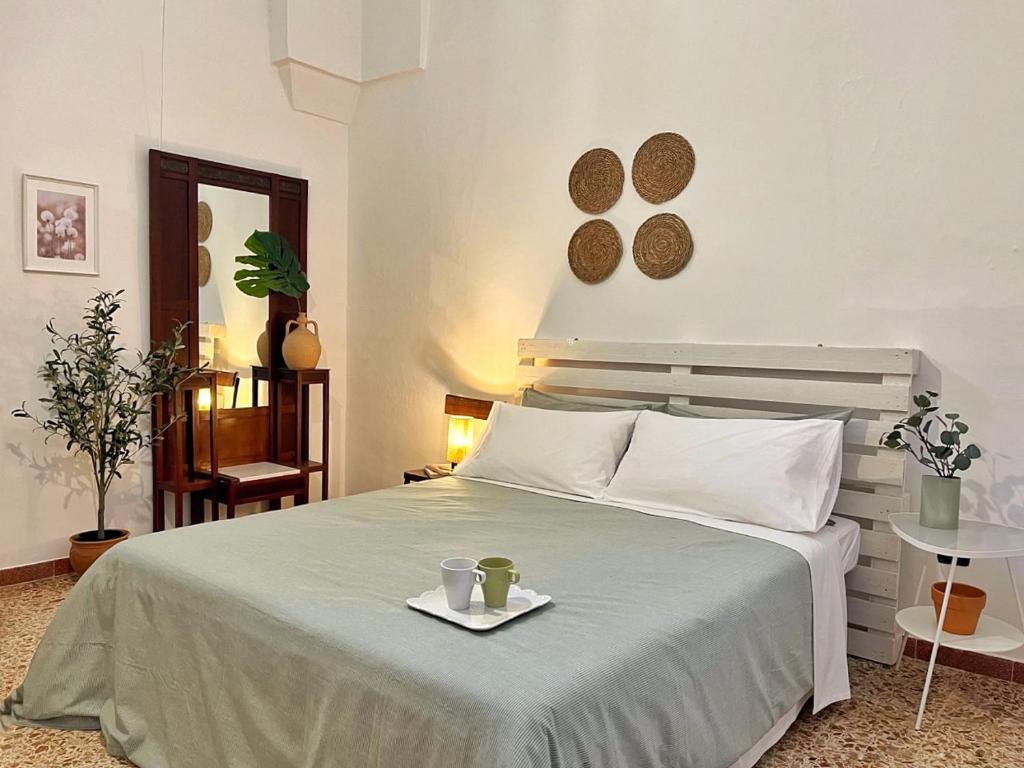 een slaapkamer met een bed en een dienblad met twee kopjes erop bij La Casetta in Muro Leccese