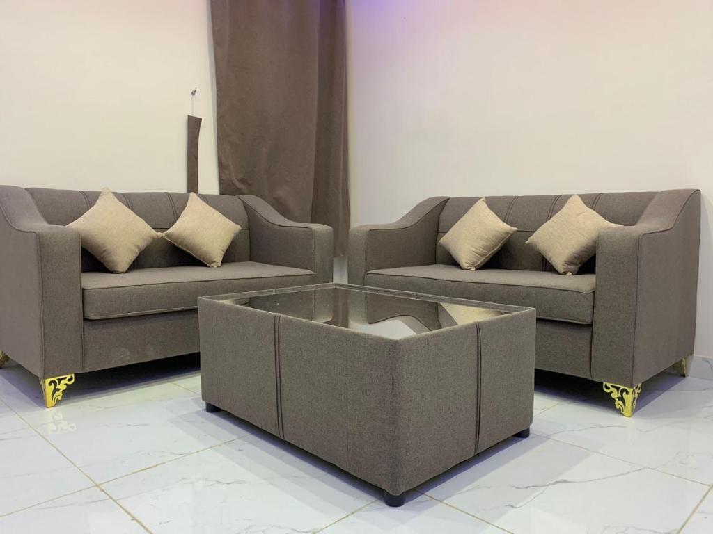 a living room with two couches and a coffee table at أجنحة عبدالعزيز للوحدات السكنية in Sulţānah