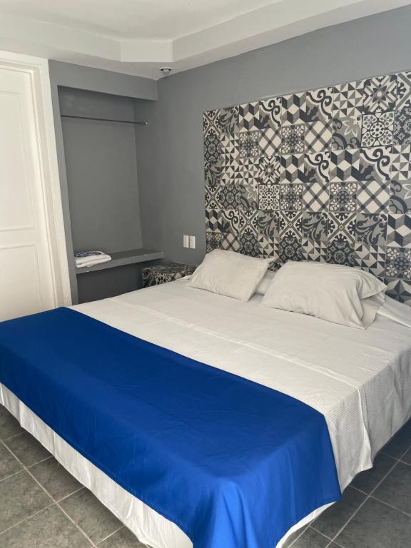 Un dormitorio con una cama azul y blanca con una pared en Hotel Rias en Veracruz
