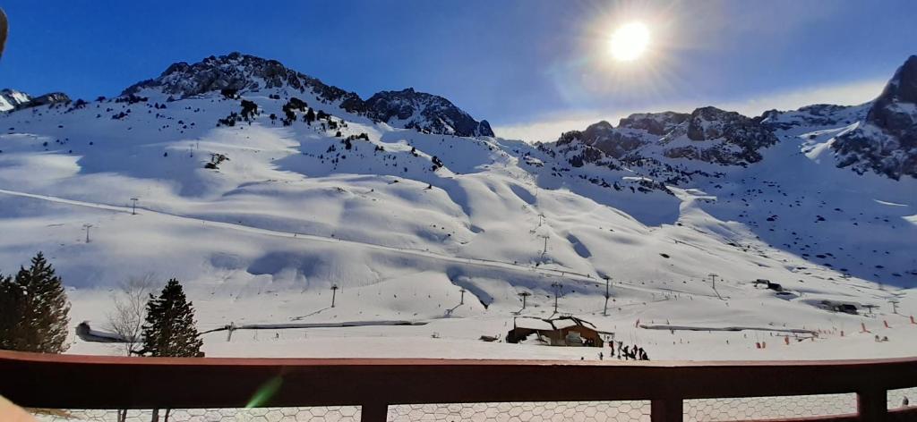 uma vista para uma montanha coberta de neve com o sol em La Mongie, Studio pieds des pistes, parking intérieur privé em La Mongie