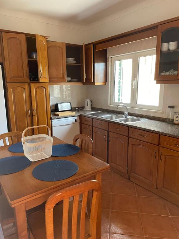 a kitchen with wooden cabinets and a wooden table at Quinta dos Moledros in Figueira